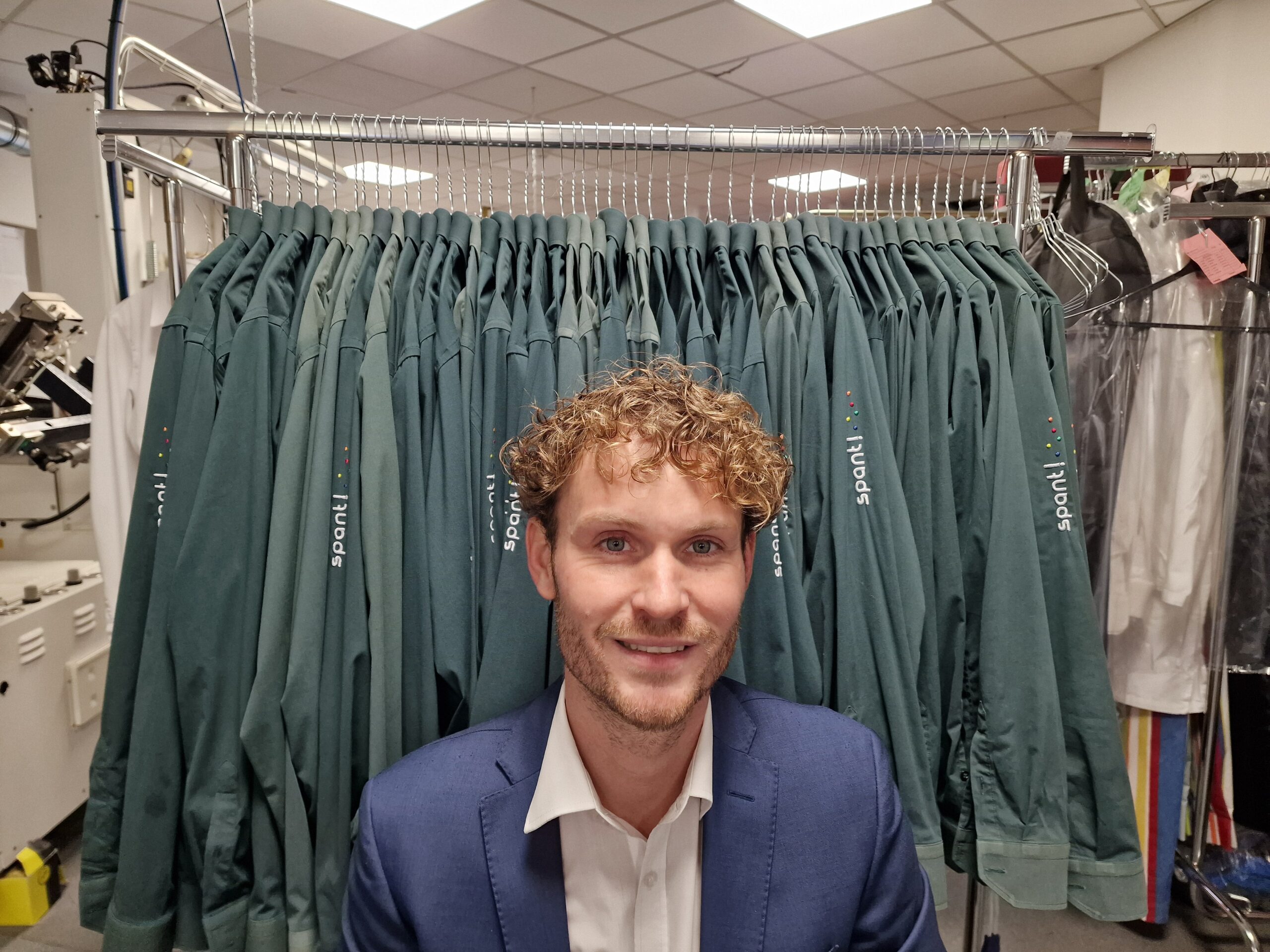 Tonio voor een rek met overhemden